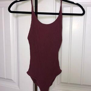 Out from under maroon bodysuit